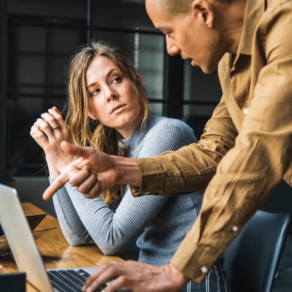 Two workers discuss solutions for digital marketing strategy.